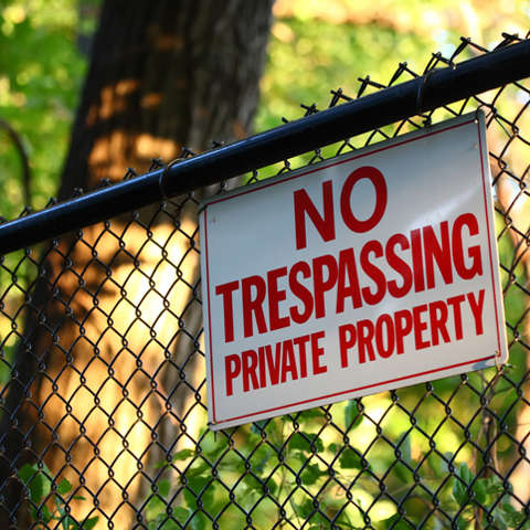 No trespassing private property sign on fence.