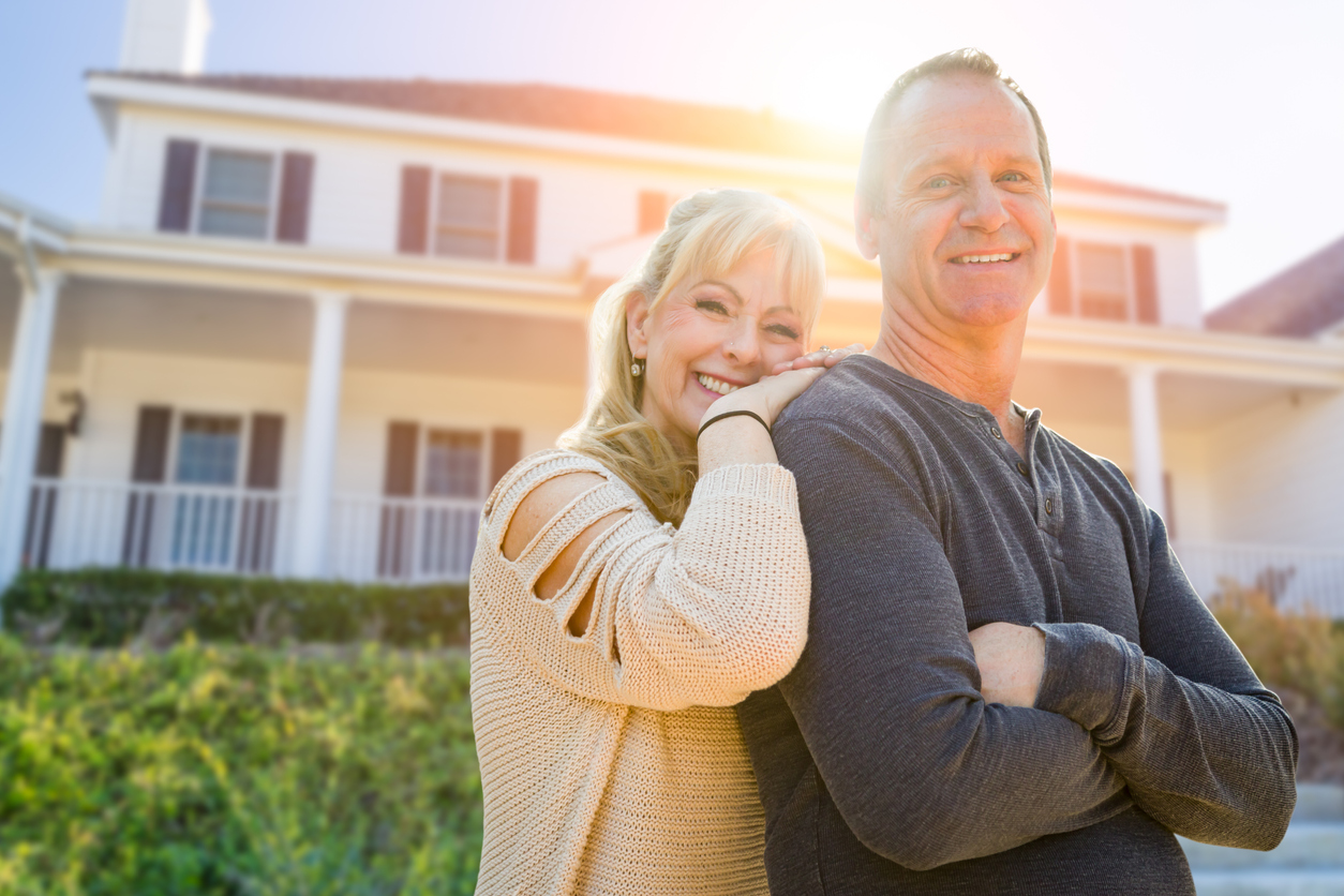 middle aged couple in front of house